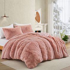 a bed with pink comforters and pillows in a bedroom