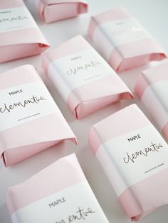 pink and white candy wrappers sitting on top of each other with writing on them