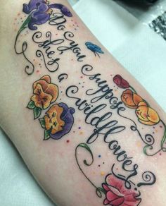 a woman's arm with flowers and the words happy birthday written on it in cursive writing