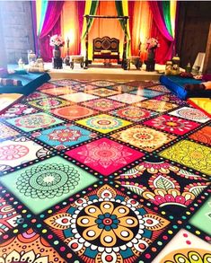 a colorful carpet is on the floor in front of a stage with lights and curtains