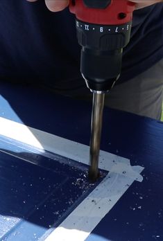 a person using a drill to cut out the bottom part of a piece of wood