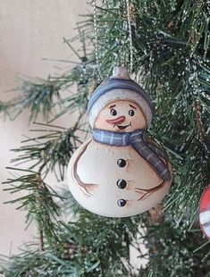 a snowman ornament hanging from a christmas tree