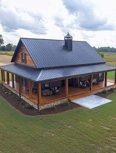 an aerial view of a house in the middle of a field with a metal roof