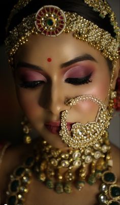 a woman with makeup and jewelry on her face