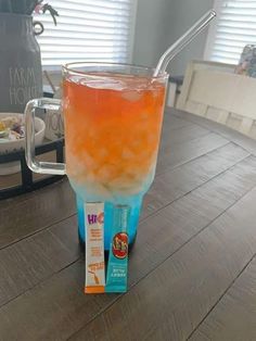 an orange and blue drink sitting on top of a table next to a box of milk