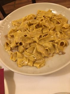 a white plate topped with pasta covered in sauce