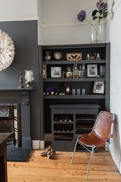 a living room filled with furniture and a fire place next to a wall mounted book shelf