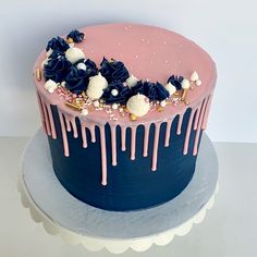 a blue and pink cake with white flowers on top