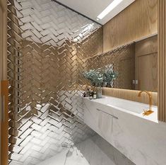 a bathroom with white counter tops and wooden accents on the walls, along with a large mirror