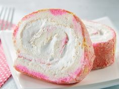 two pieces of pink and white cake roll on a plate