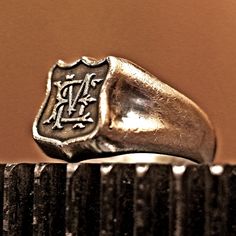 This ring has medieval style raised monogram in a shield shape face. The ring base is RS-173 Buck(Stag) Head ring. The monogram can be personalized. -PRECAUTION- Every ring I make are true to size. I always consider width of the rings when I work on sizes. Please do not order larger or smaller than your finger size. Measuring your finger with string, tape measure or paper strip is not accurate at all. And measuring your own ring by diameter is even worse. Please measure your finger from a jewelr Classic Silver Signet Ring With Maker's Mark, Vintage Silver Monogram Rings, Vintage Silver Monogram Engraved Ring, Vintage Monogram Oval Signet Ring, Vintage Sterling Silver Initial Ring, Vintage Sterling Silver Engraved Ring With Initials, Vintage Monogram Ring Jewelry, Vintage Sterling Silver Rings With Initials, Mans Ring