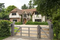 a large house with a gate in front of it and trees around the yard area