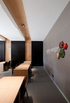 an empty conference room with wooden tables and black chairs, in front of a sign that reads bush magnets on the wall