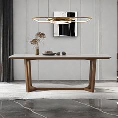 a wooden table sitting in the middle of a room next to a chair and vase