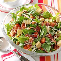 a salad with lettuce, tomatoes and croutons in it on a plate