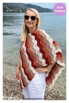 a woman is standing on the beach wearing a crocheted shawl and sunglasses