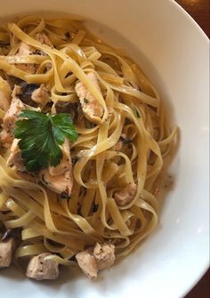 a white bowl filled with pasta and meat