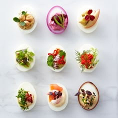 several different types of appetizers are arranged on a white surface