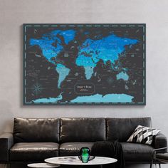 a living room with a black couch and a large map on the wall above it