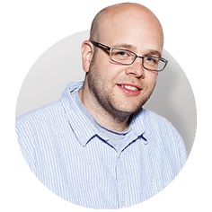 a man with glasses and a blue shirt in front of a red circle on a white background