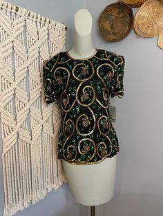 Vintage 1980s Papell boutique beaded green and gold blouse. Size Petite Small. Excellent never worn vintage condition. This gorgeous blouse still has its original tags attached as well as a repair kit.  Measurements in inches (garment laying flat) Pit to pit: 17 Sleeve: 9 Shoulders: 14.5 Length: 23 Festive Green Sequined Tops, Festive Green Sequin Tops, Green Sequined Short Sleeve Tops, Vintage Gold Blouse For Party, Green Sequined Blouse For Evening, Vintage Blouse For Festive Occasions, Vintage Green Blouse For Party, Green Embellished Festive Tops, Embellished Green Tops For Festive Occasions