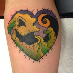 a tattoo with an image of jack and sally in the shape of a heart on someone's leg