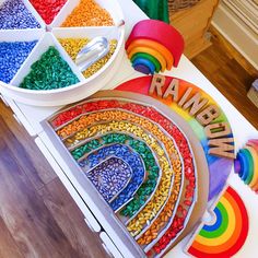 a rainbow themed cake on a table with lots of colorful candies in the middle