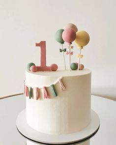 a birthday cake decorated with balloons and streamers