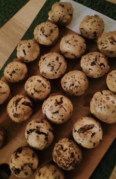 chocolate chip muffins sitting on top of a wooden cutting board