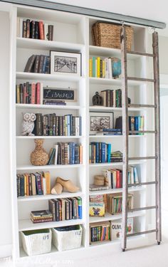 an old ladder is used as a bookshelf in this white bookcase filled with books