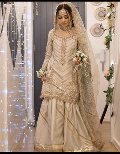 a woman in a white and gold wedding outfit