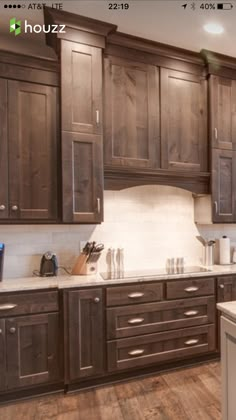 a large kitchen with wooden cabinets and white counter tops, along with an island in the middle