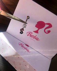 a pair of scissors is being used to cut the paper for barbie's hair