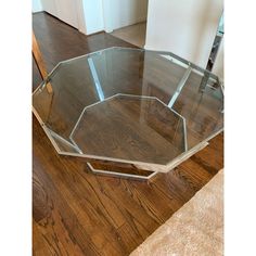 a glass and chrome coffee table on wooden floor