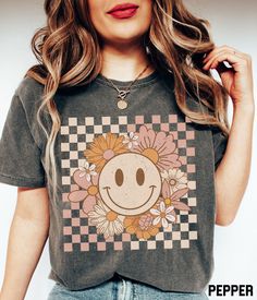 Our cute and retro flower smiley face graphic tee features a distressed floral happy face on a checkered background design. This oversized t-shirt is available in a variety of colors and you'll love the comfortable material of the Comfort Colors fabric. It ensures a soft and comfortable feel that will keep you feeling good all day long. ✩ Smiley Face Shirt, Flower Shirt, Retro Smile Face, Trendy Vintage Graphic Tee, Checkered Comfort Colors T-shirt, Plus Size Happy Face Tshirt SIZE UP for an OVE Affordable Fun Smiley Face T-shirt, Smile Graphic, Flower Smiley, Smiley Face Tee, Smiley Face Tshirt, Checkered Background, Smiley Face Shirt, Trending Graphic Tees, 80s Tees