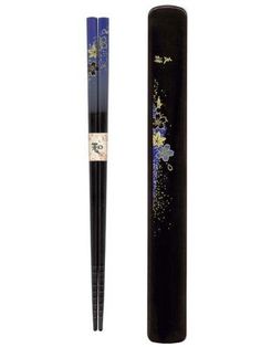 a black pen with blue and gold designs on the side, next to it's holder