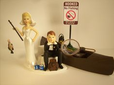 a wedding cake topper sitting next to a fake bride and groom