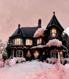 a large black house with pink flowers on the front