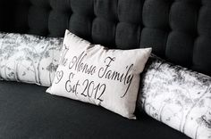 a black couch with two pillows on it and the names of their family printed on them