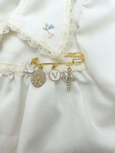 a close up of a white dress with some charms on the front and back of it