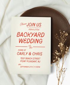 a wedding card sitting on top of a plate