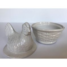 a ceramic chicken next to a bowl on a table