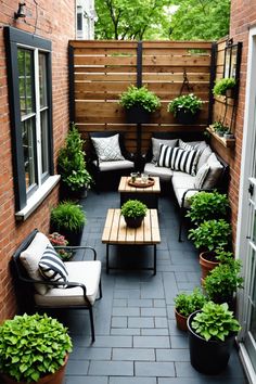 an outdoor seating area with potted plants and couches on the side of a brick building