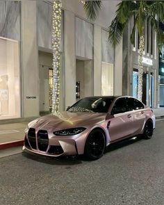 a silver car parked on the side of a street next to tall buildings with palm trees in front of it