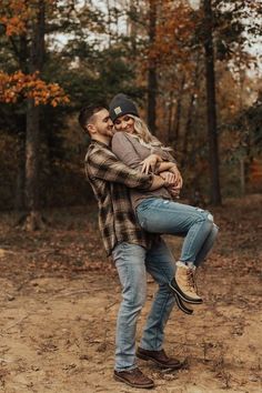 a man carrying a woman on his back in the woods during fall or early autumn