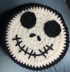 a crocheted pillow with a smiling face on it's side, made to look like jack skellingy