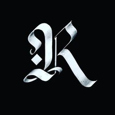 the letter k is made up of silver foil on a black background, and it appears to be in cursive writing