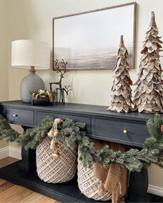 christmas decorations are displayed on a mantle in the living room with pine cones and burlocks