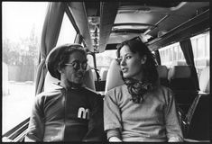 a man and woman sitting in the back of a bus