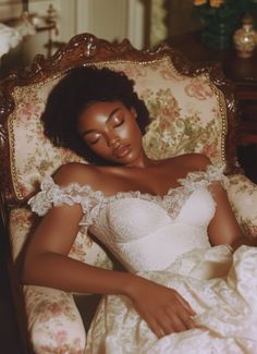 a woman in a white dress is laying down on a chair with her eyes closed